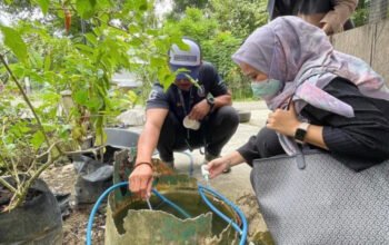 Petugas kesehatan saat mengecek kondisi genangan air di sekitar rumah warga beberapa waktu lalu. KATAKUNCI/ah