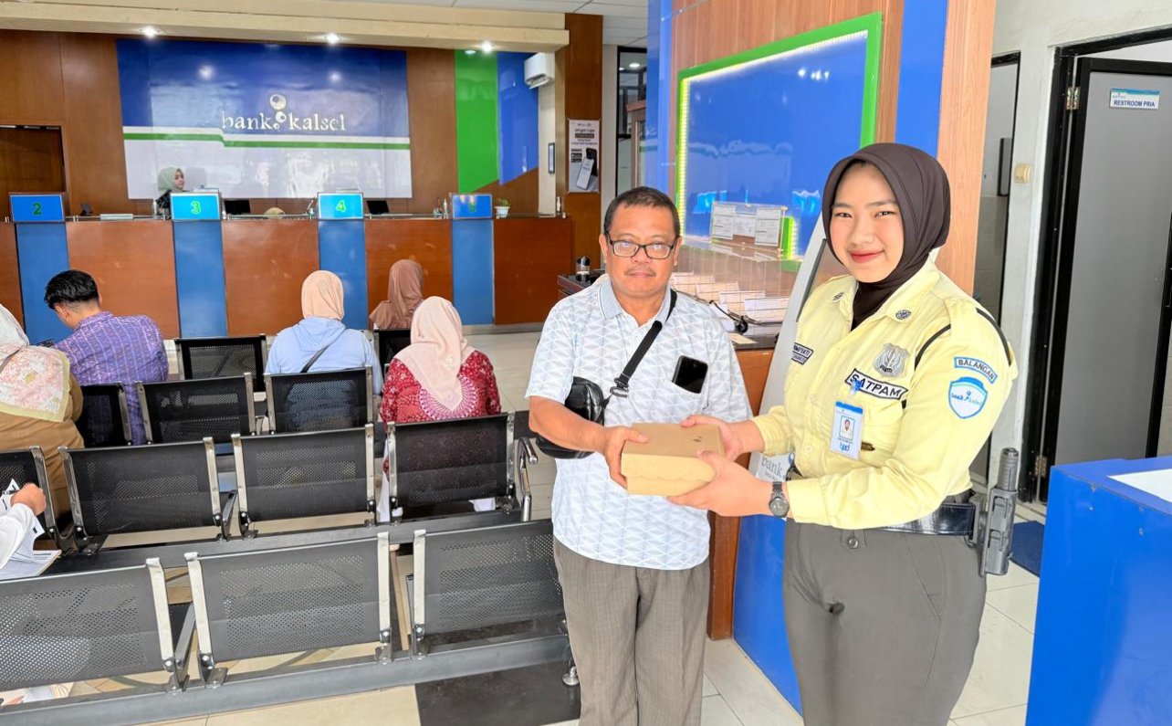 Security Bank Kalsel KC Paringin saat memberikan nasi kota kepada salah satu nasabah, Selasa (16/9/2025). KATAKUNCI